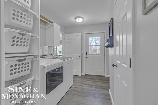 laundry room with washer and dryer, wood finished floors, and baseboards