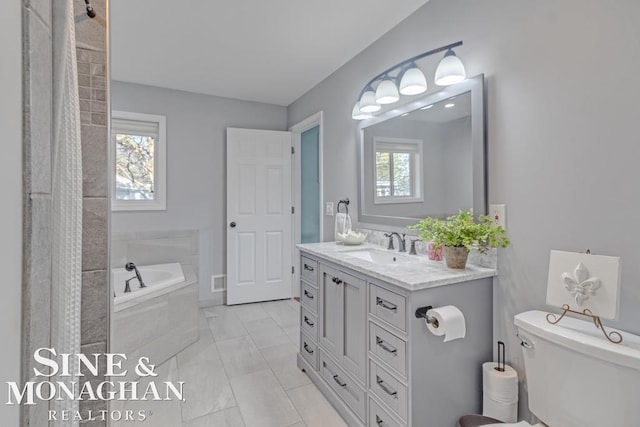 full bathroom featuring toilet, marble finish floors, a bath, and vanity
