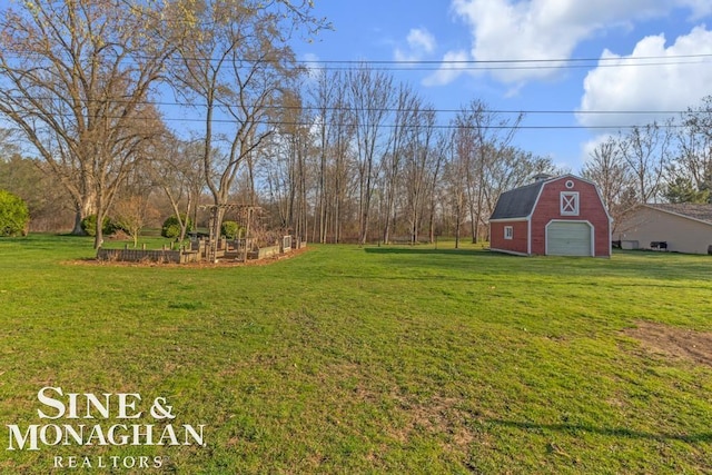 view of grassy yard with a barn, a garage, and an outbuilding