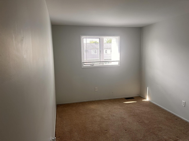 empty room featuring carpet floors and baseboards