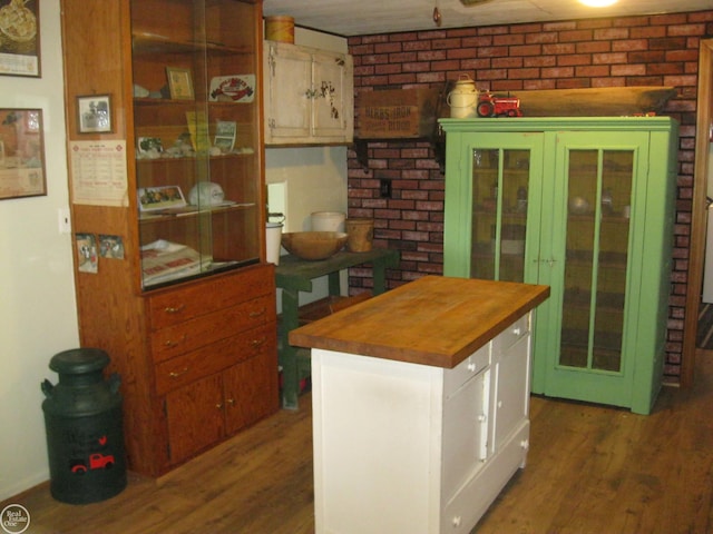 kitchen featuring wood finished floors, butcher block counters, and white cabinetry