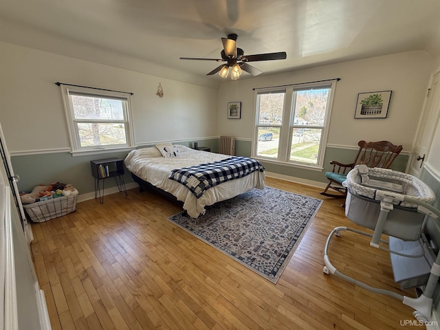 bedroom with wood finished floors, baseboards, and a ceiling fan