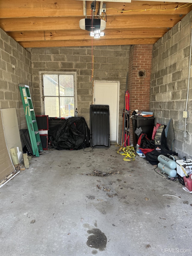 garage with a garage door opener and concrete block wall