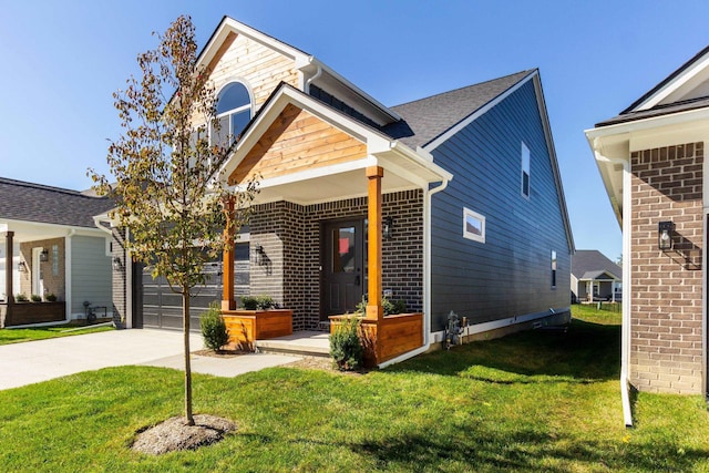 view of front of home with driveway, a front yard, an attached garage, and brick siding