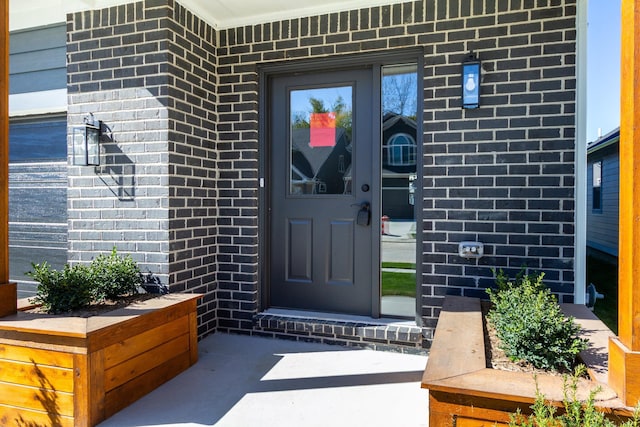 doorway to property featuring brick siding
