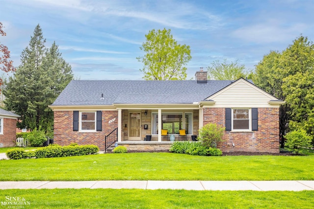 single story home featuring a porch, brick siding, a chimney, and a front yard