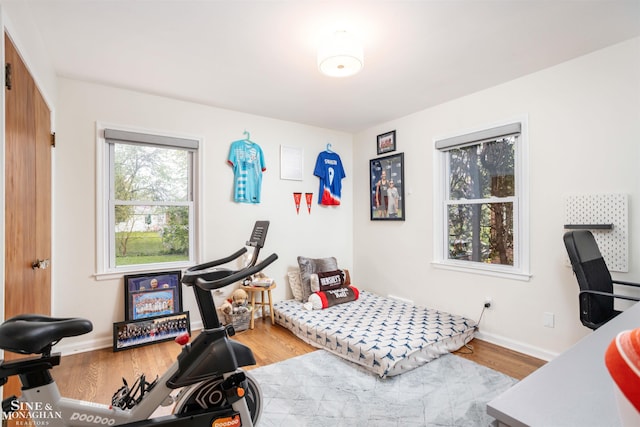bedroom with wood finished floors and baseboards