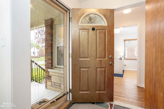 foyer with baseboards and wood finished floors