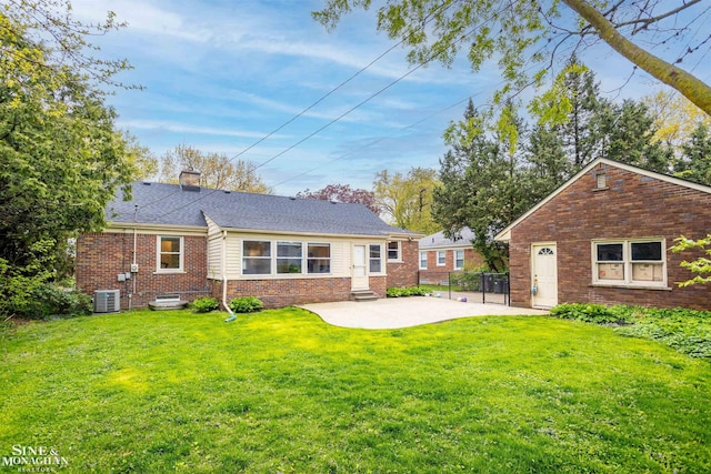 rear view of property with brick siding, a patio area, central air condition unit, a chimney, and entry steps