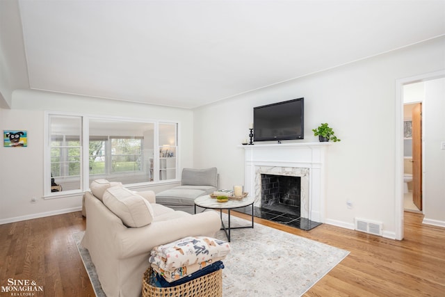 living room with wood finished floors, a fireplace, and baseboards