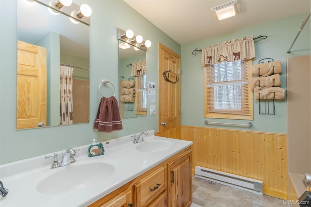 112 Little Deer Rd, Iron River, MI 49935 - bathroom featuring a baseboard radiator, wooden walls, double vanity, a wainscoted wall, and a shower with shower curtain