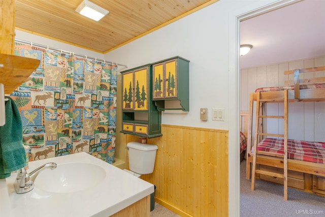 112 Little Deer Rd, Iron River, MI 49935 - bathroom featuring wooden walls, wainscoting, a shower with shower curtain, ornamental molding, and toilet