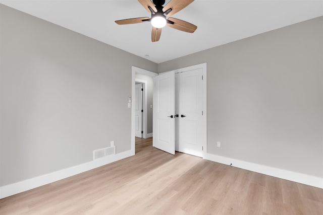 unfurnished bedroom with baseboards, wood finished floors, and a closet