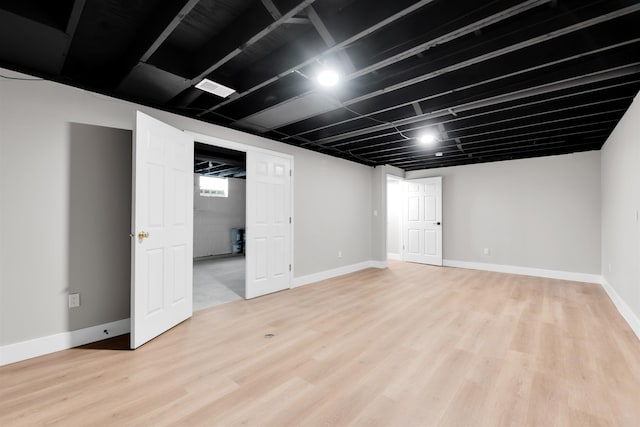 below grade area featuring light wood-style floors and baseboards
