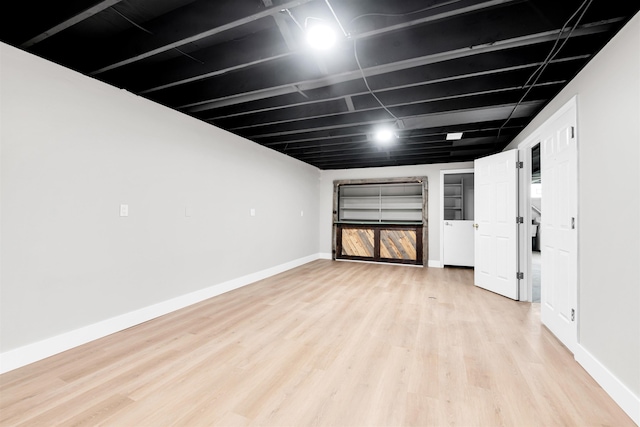 below grade area with light wood finished floors and baseboards