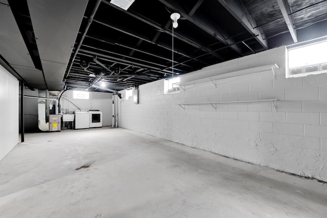 basement featuring heating unit, a sink, and independent washer and dryer