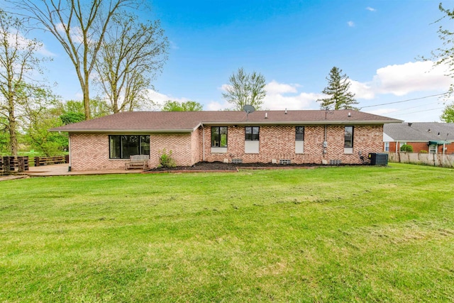 back of property featuring central AC unit, brick siding, and a patio area