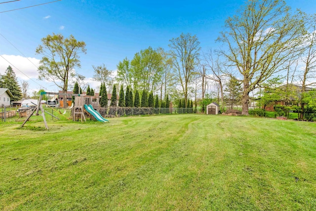view of yard with a playground, a storage unit, and an outdoor structure