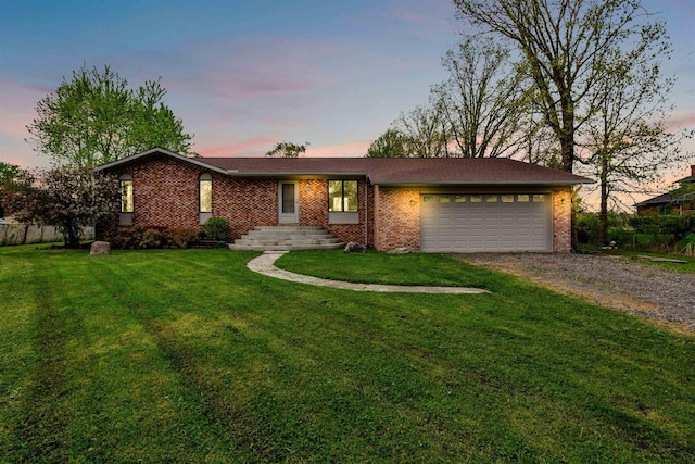 single story home with driveway, brick siding, a garage, and a yard