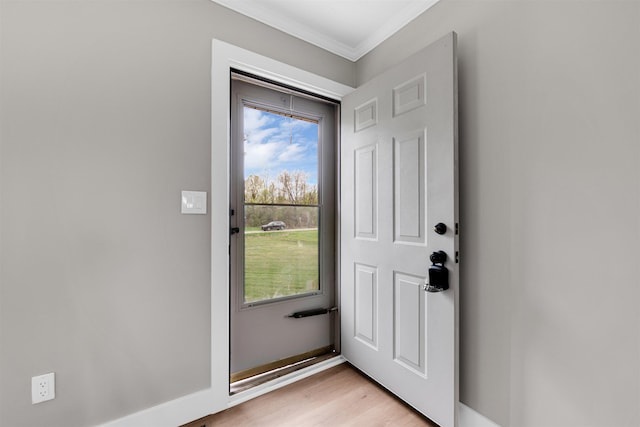 entryway with ornamental molding and light wood-type flooring