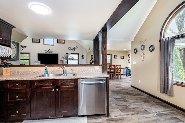kitchen featuring stainless steel dishwasher, lofted ceiling, a sink, dark brown cabinetry, and light wood finished floors