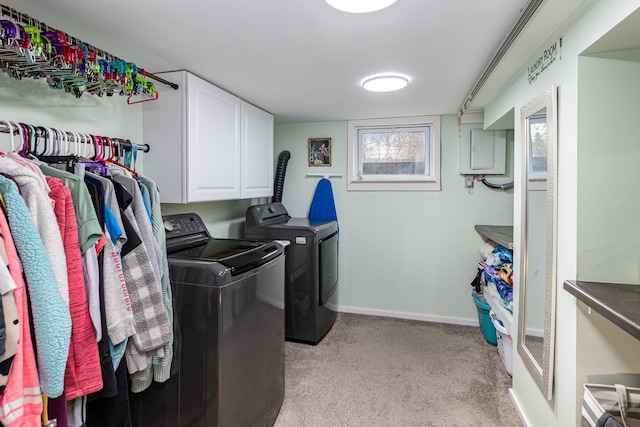 washroom featuring cabinet space, washing machine and clothes dryer, electric panel, light carpet, and baseboards