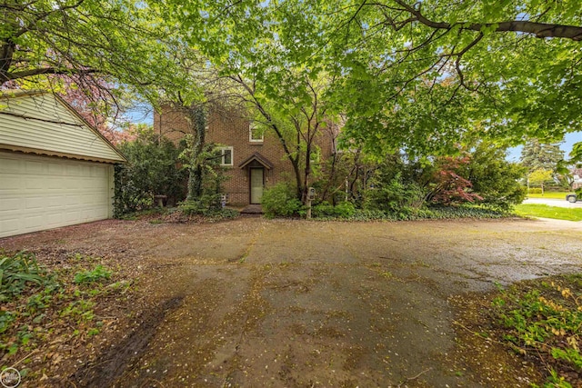 view of front facade with driveway, a garage, and brick siding