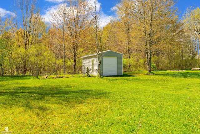 view of green lawn with an outbuilding and a garage