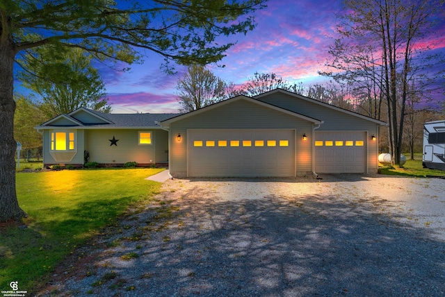 ranch-style house with driveway, a garage, and a front lawn