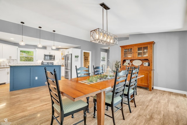 dining space featuring light wood-style flooring, baseboards, a chandelier, and recessed lighting
