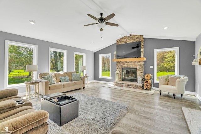 living area featuring a stone fireplace, healthy amount of natural light, ceiling fan, and recessed lighting
