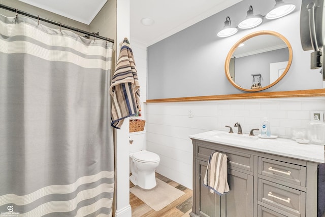 bathroom featuring ornamental molding, wood finished floors, toilet, vanity, and a shower with curtain
