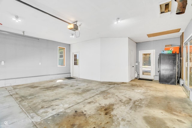 garage with freestanding refrigerator and a garage door opener