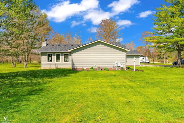view of side of property featuring a chimney and a lawn