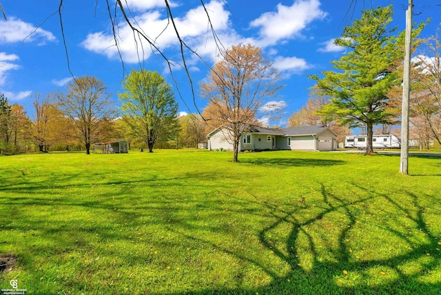 view of green lawn with a garage