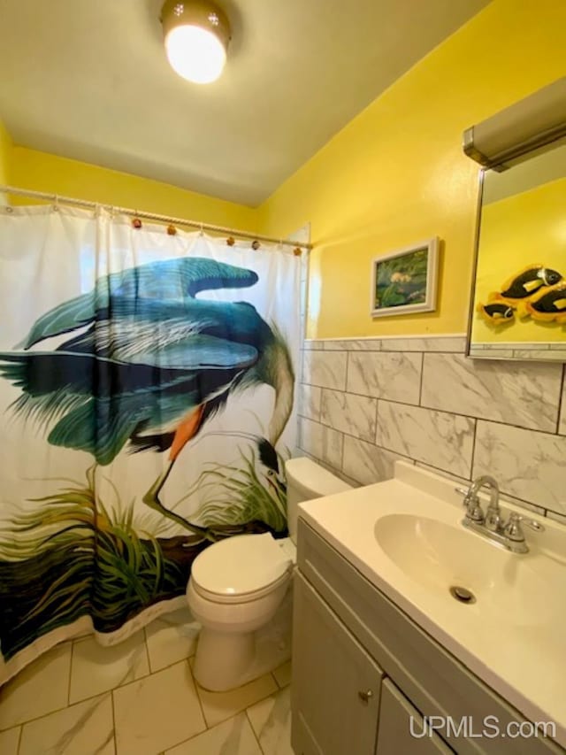 bathroom with vanity, toilet, tile walls, vaulted ceiling, and curtained shower