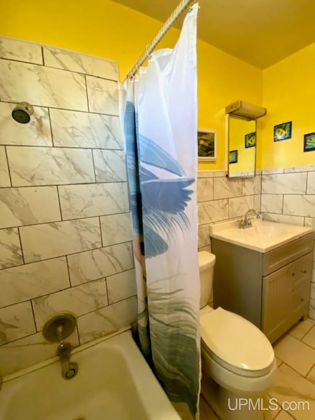 full bathroom with tile walls, toilet, vanity, shower / bathtub combination with curtain, and wainscoting