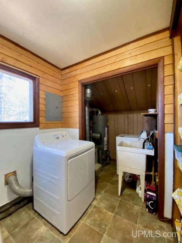 washroom featuring washer / clothes dryer, gas water heater, wooden walls, and electric panel