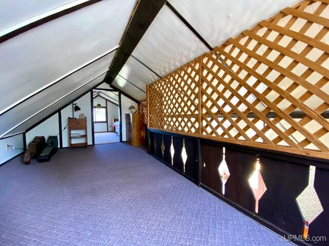 additional living space with vaulted ceiling and carpet flooring