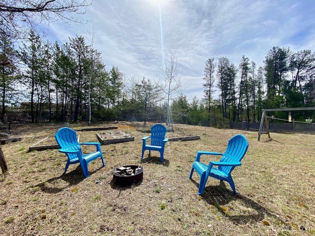 view of home's community featuring a fire pit and fence