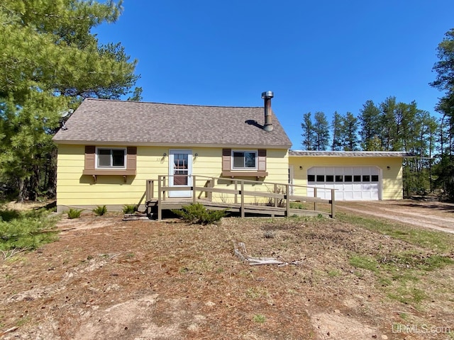 view of front of house featuring driveway, a deck, an attached garage, and a shingled roof