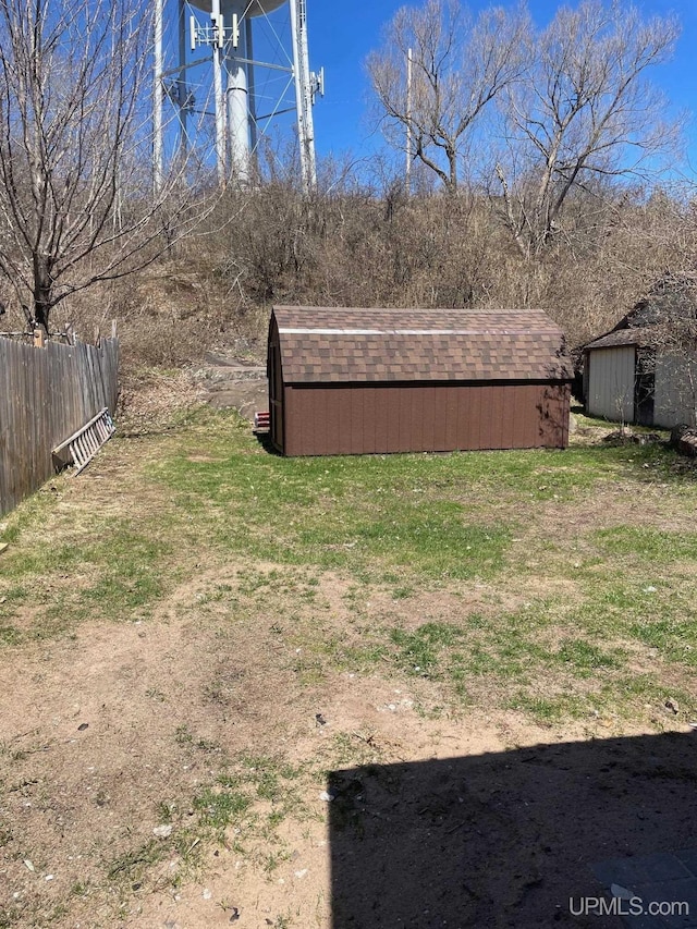 122 Rock St, Negaunee, MI 49866 - view of yard featuring fence, an outbuilding, and a storage unit