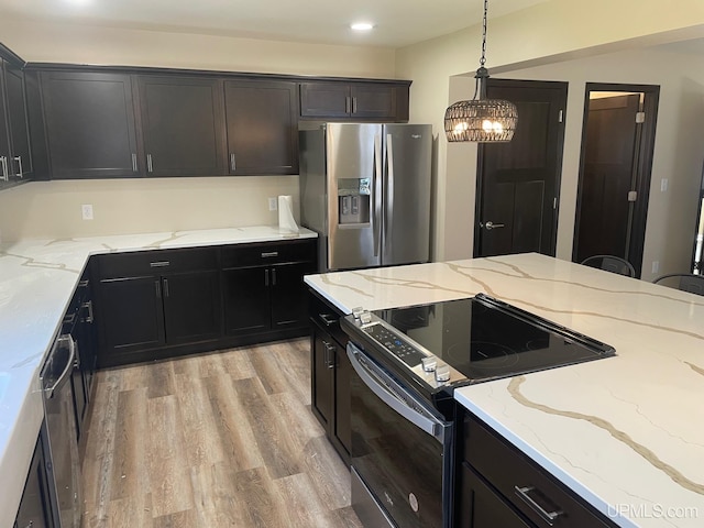 122 Rock St, Negaunee, MI 49866 - kitchen with appliances with stainless steel finishes, a chandelier, light wood finished floors, pendant lighting, and light stone counters