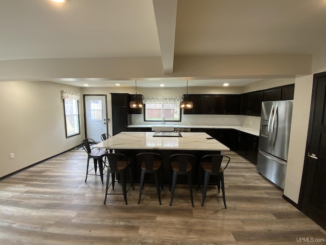 122 Rock St, Negaunee, MI 49866 - kitchen featuring stainless steel refrigerator with ice dispenser, a center island, healthy amount of natural light, recessed lighting, and a breakfast bar area