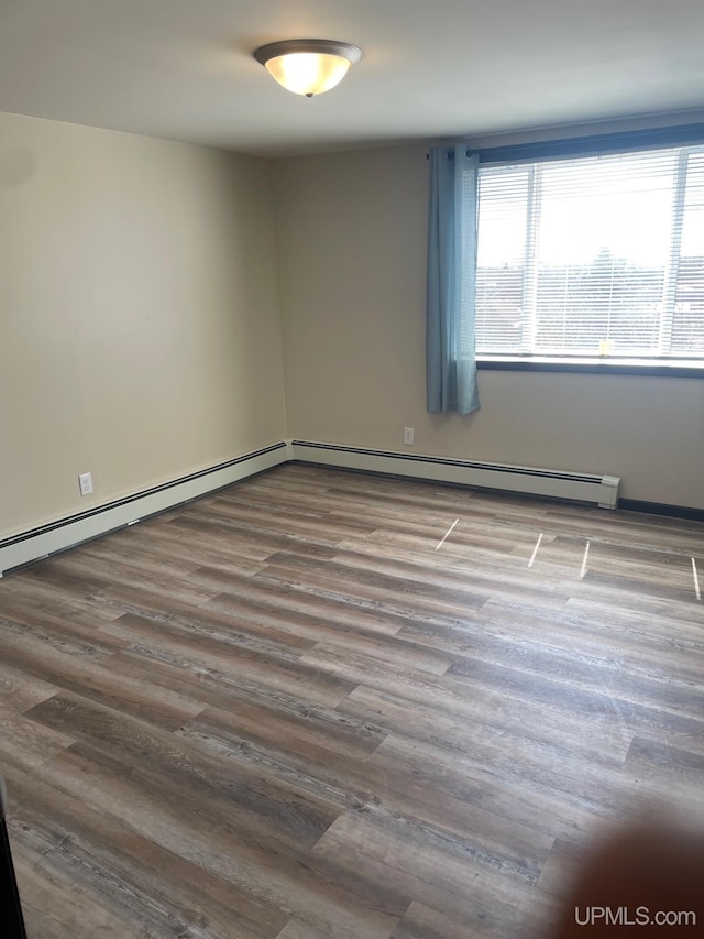 122 Rock St, Negaunee, MI 49866 - unfurnished room with wood finished floors and baseboard heating
