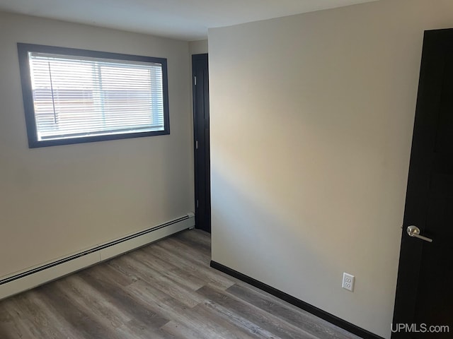 122 Rock St, Negaunee, MI 49866 - unfurnished room with a baseboard radiator and wood finished floors