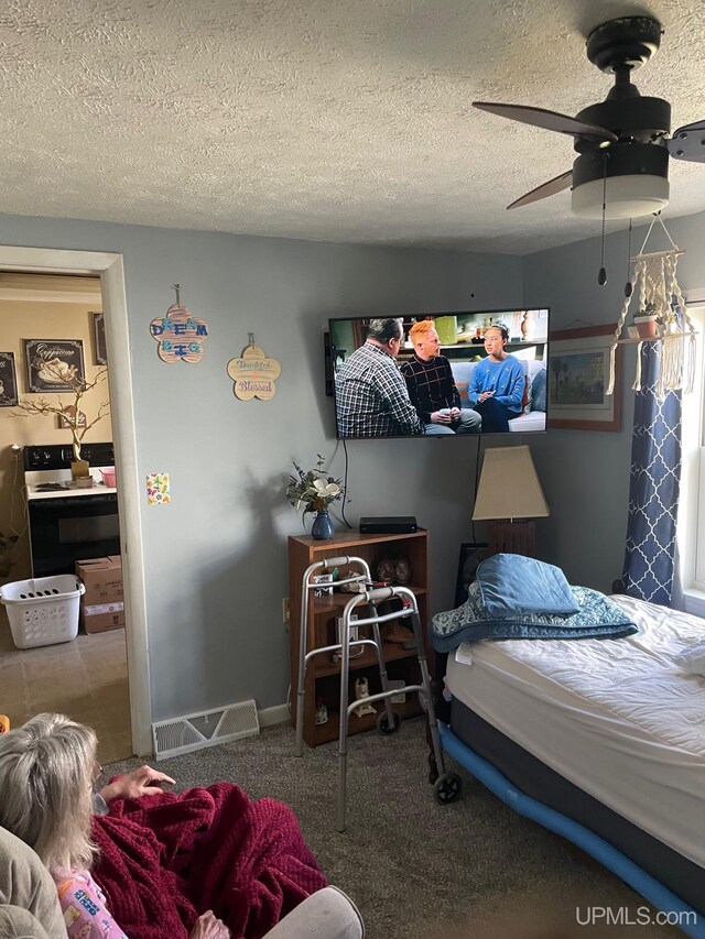 carpeted bedroom featuring a textured ceiling and ceiling fan