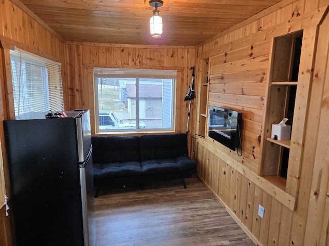 living area with wood walls, wood ceiling, and wood finished floors