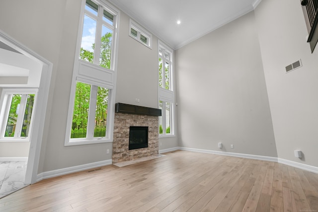 835 Crestwood Ln, Rochester Hills, MI 48309 - unfurnished living room featuring a towering ceiling, ornamental molding, baseboards, plenty of natural light, and a fireplace