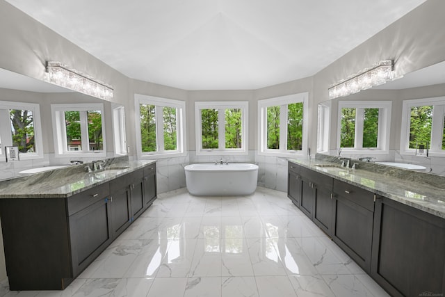 835 Crestwood Ln, Rochester Hills, MI 48309 - bathroom with tile walls, a freestanding tub, marble finish flooring, and two vanities